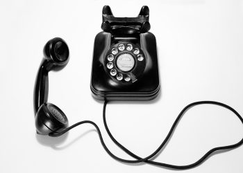 black rotary dial phone on white surface